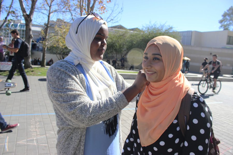 Fatima Haghi, vice president of UCSD’s Muslim Student Association, helps Hijab Day Challenge participant Hibah Khan put on a  headscarf. Photo by Nadah Feteih / UCSD Guardian.