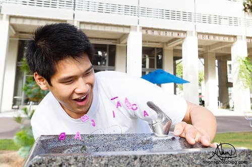 Kevin Huynh drinking from Michael Asher's Untitled fountain, rumored to grant "A"s if sipped from before taking a midterm. Photo courtesy of Nhan Nguyen.