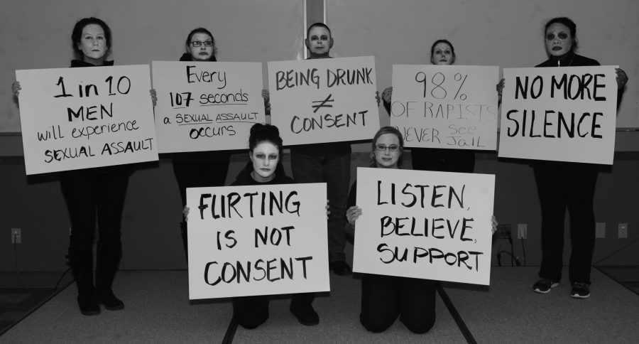 Participants in the “living display” hold up signs during the Sexual Assault Awareness and Prevention Month kickoff event at Ellsworth Air Force Base, S.D., April 1, 2016. The display included individuals holding signs depicting sexual assault statistics in order to raise awareness of the crime. (U.S. Air Force photo by Airman 1st Class Denise M. Nevins/Released)